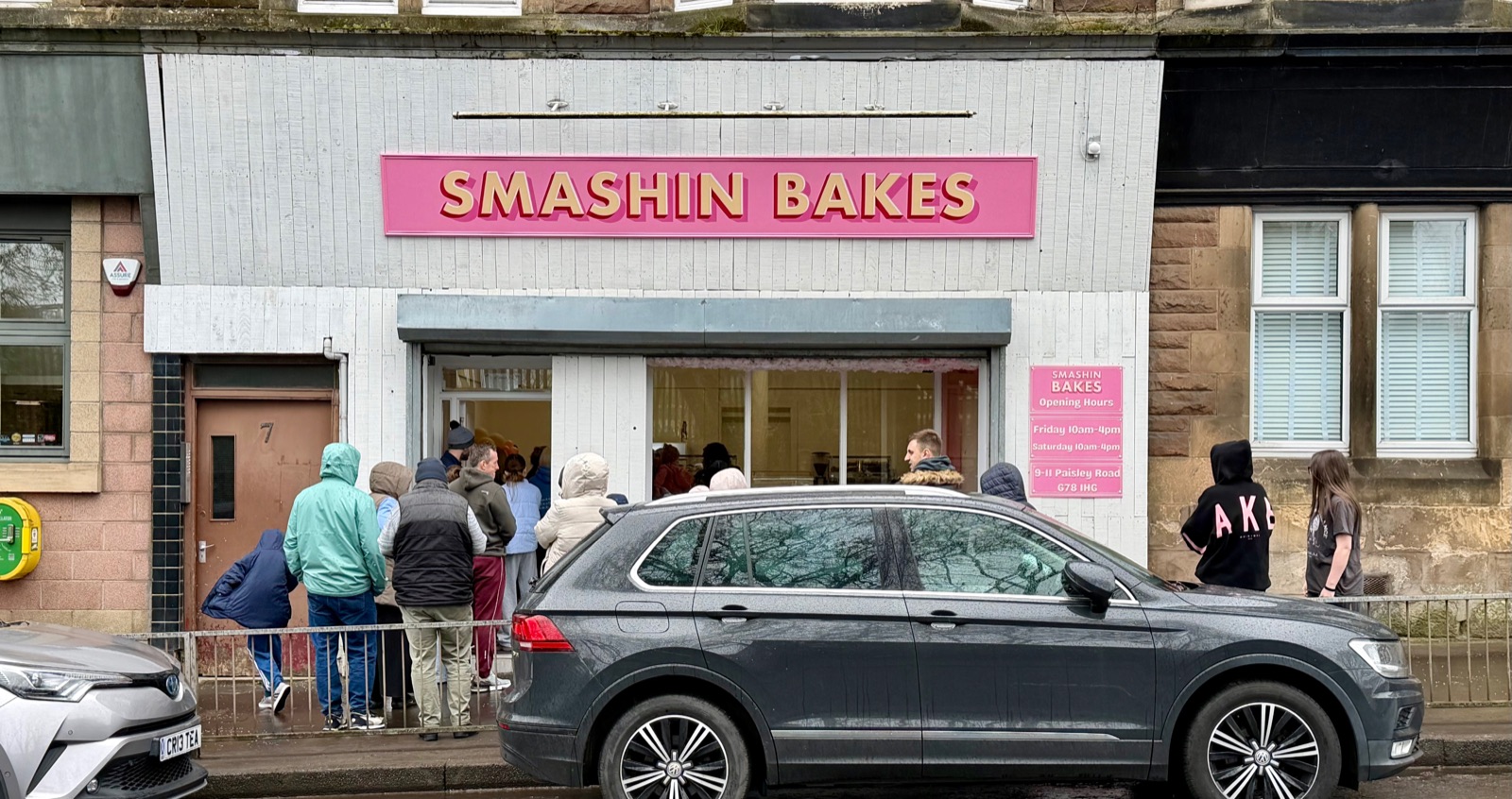 The Smashin' Bakes shop front on Paisley Road, with its pink sign and a queue of happy customers outside